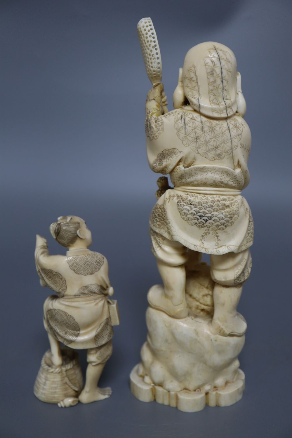 A Japanese ivory okimono of an elder and a dragon, and a marine ivory carving of Daikoku, tallest 25cm